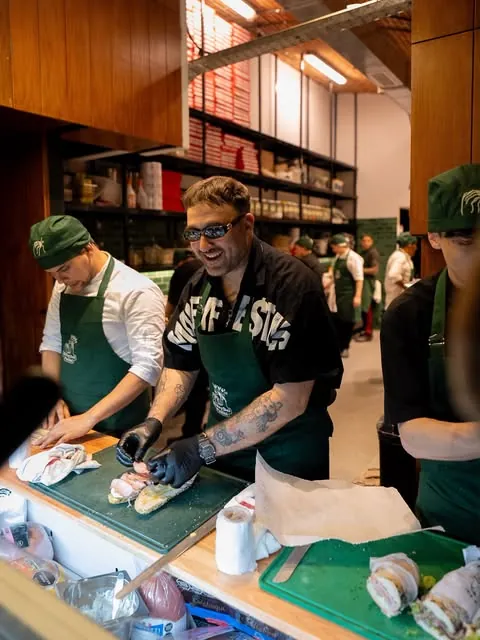 El equipo armando paninis detrás del mostrador